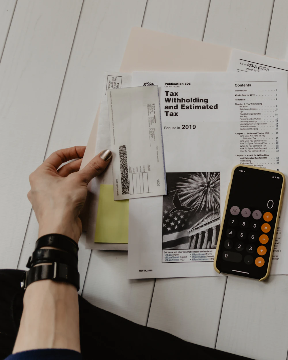 Tax forms, a pen and a phone calculator on a desk