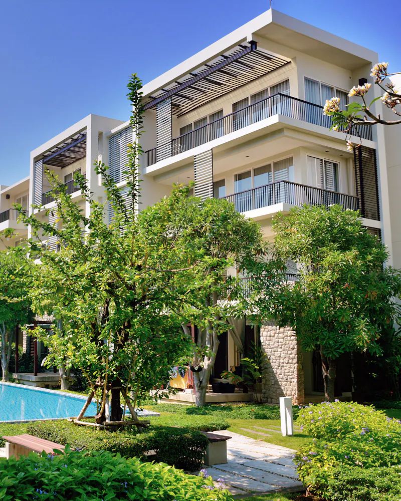 An apartment community with a pool and gardens